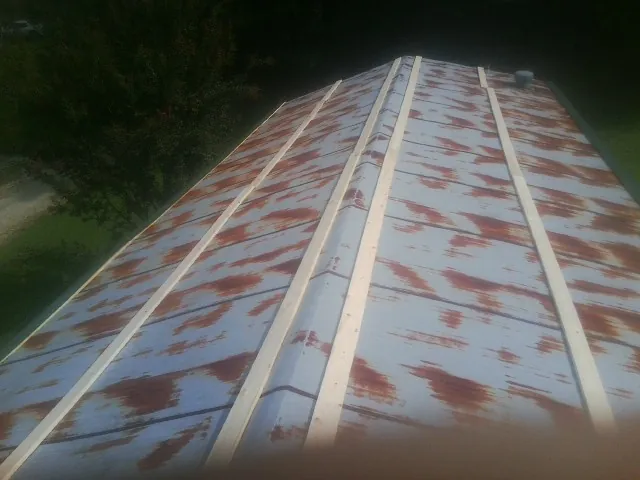 Rusted metal roof panels with new wood purlins before replacement — Storm Damage Roof Repair in Saulsbury by Roofing Brothers