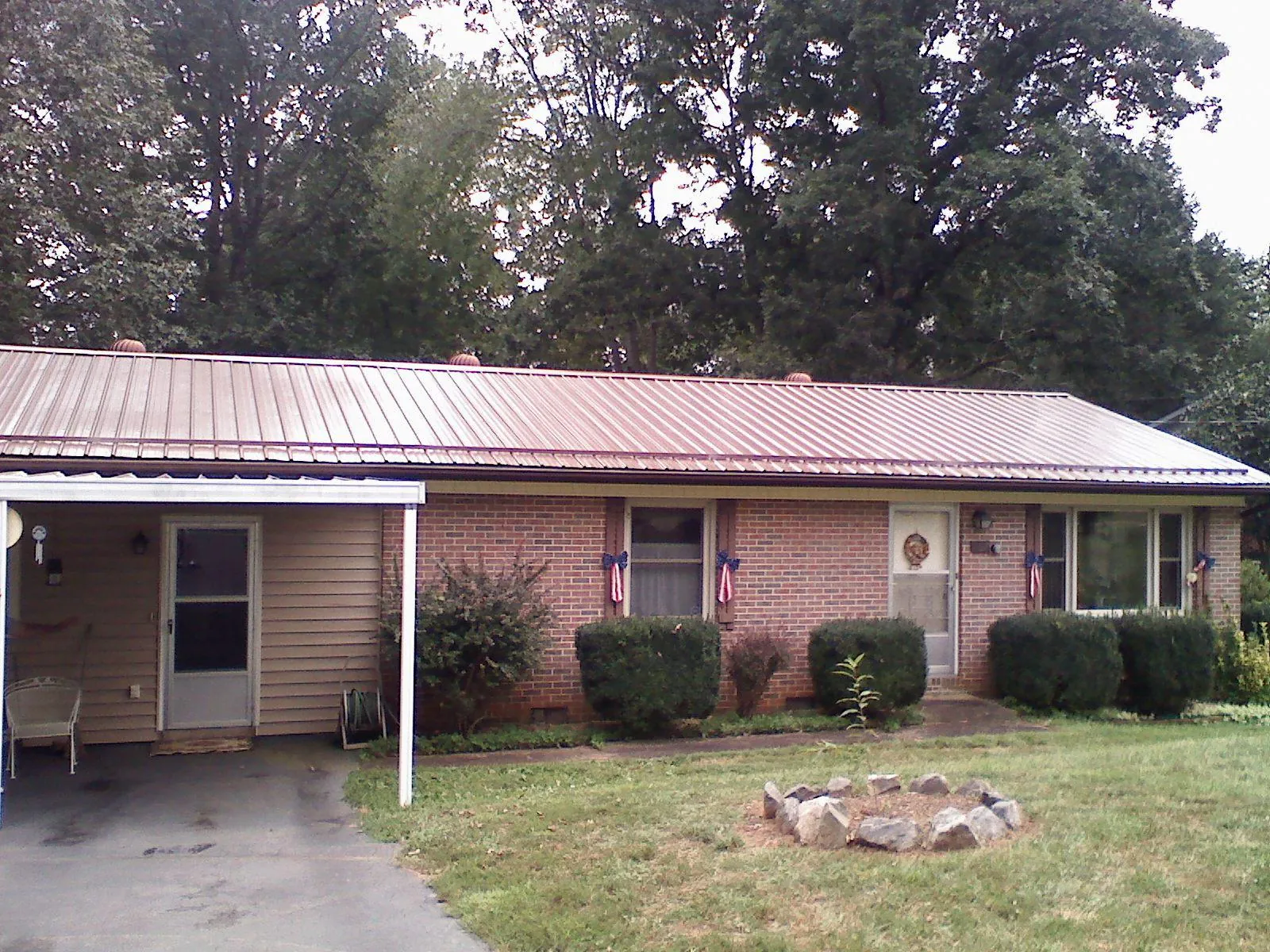 Bronze metal roof and carport on a brick ranch home — Roof Repair work by our crew in Saulsbury
